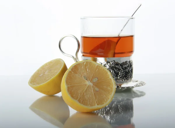 Te i glas mugg och citroner — Stockfoto