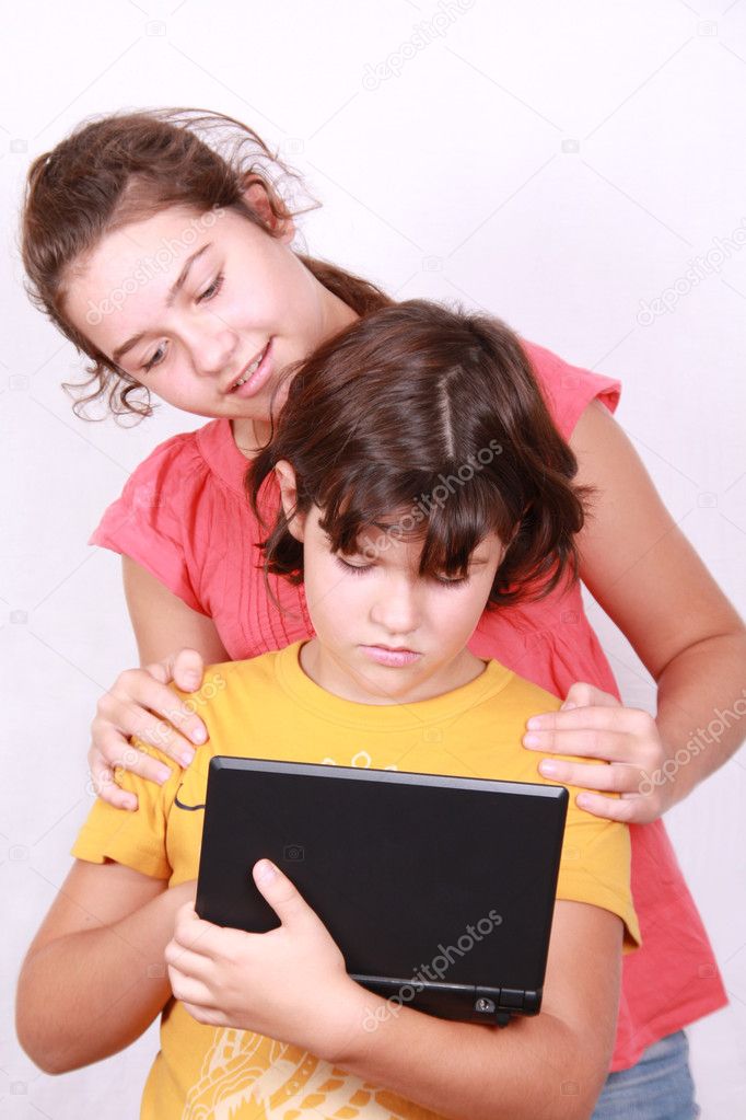 Two nice girlfriends peer into laptop