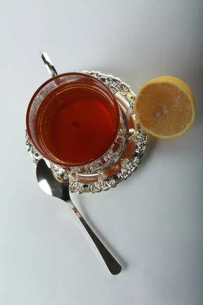 Thé dans une tasse en verre et citrons — Photo