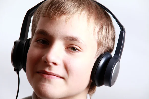 Мальчик-подросток слушает наушники — стоковое фото
