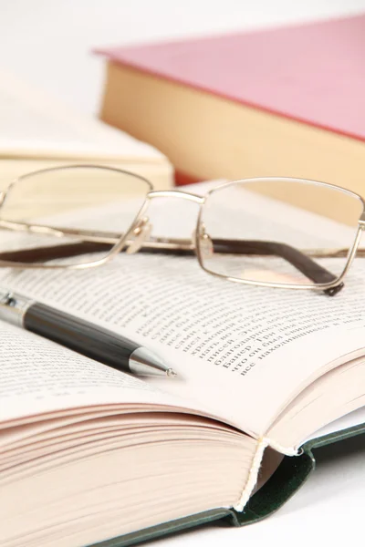 Glasögon och penna på boken — Stockfoto