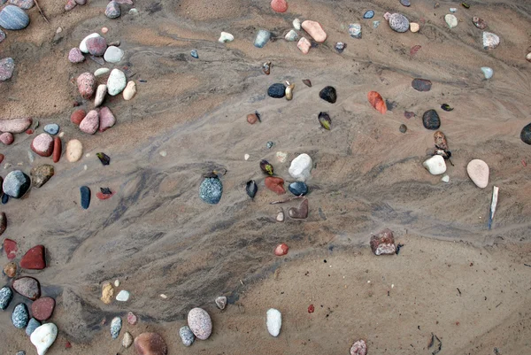 Kieselsteine auf Sandstruktur — Stockfoto