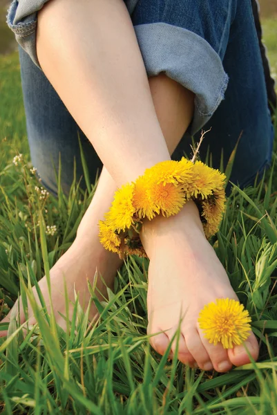 Genç kadının bacakları dandelions süslenmiş — Stok fotoğraf