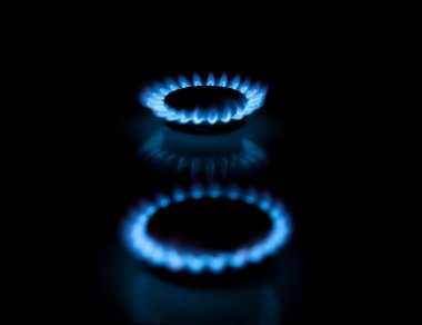 Two gas burners with flames on dark back clipart