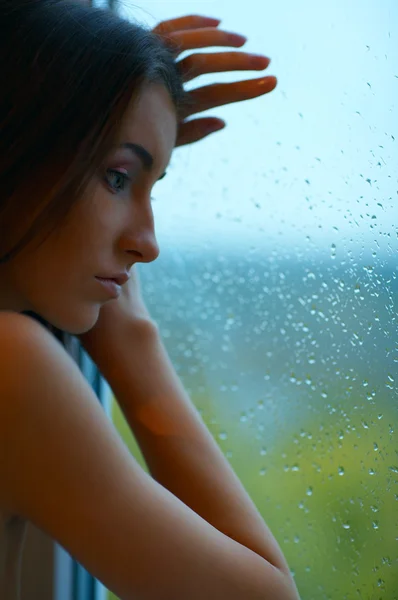 Woman and rainy window