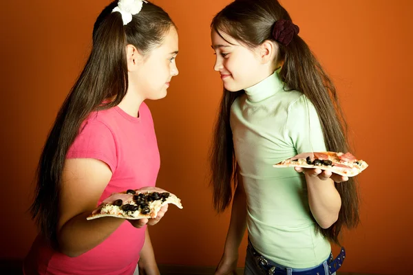 Modsat sjove piger med pizza Royaltyfrie stock-billeder