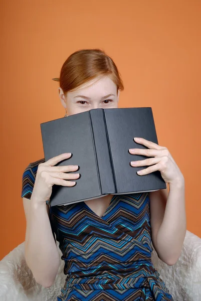 Γυναίκα κρύβει το πρόσωπο πίσω από το βιβλίο — Φωτογραφία Αρχείου