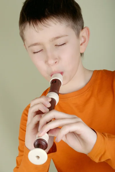 Мальчик играет на флейте — стоковое фото