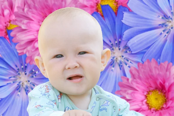Ребенок на фоне цветов — стоковое фото
