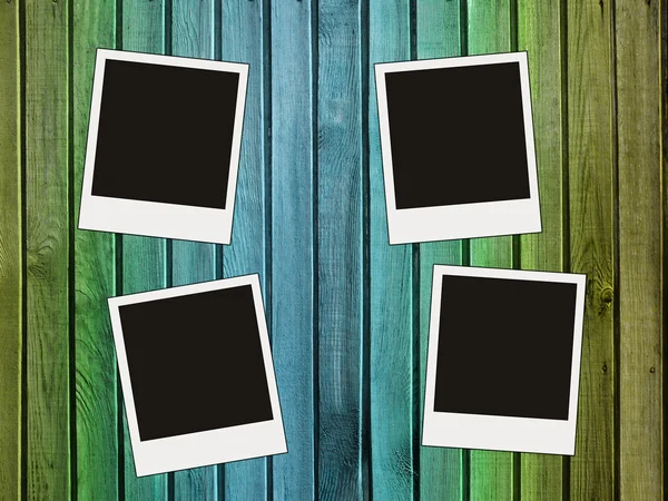 Four blank photos on wooden wall — Stock Photo, Image