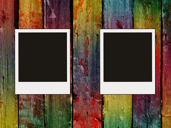 Two blank photos on colorful wooden wall — Stock Photo, Image