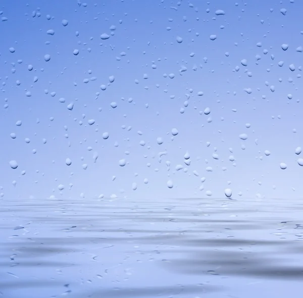 Glass with water drops on the water — Stock Photo, Image