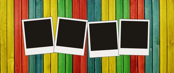Cuatro fotos en blanco en la pared de madera colorida —  Fotos de Stock