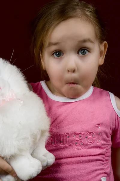A pequena menina surpreso com um brinquedo — Fotografia de Stock