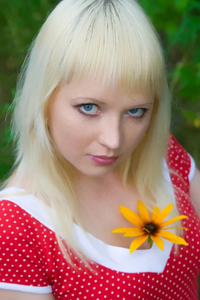 Chica joven con una flor amarilla — Foto de Stock