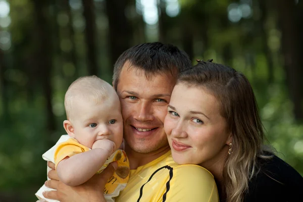 Jovem família feliz em madeira — Fotografia de Stock