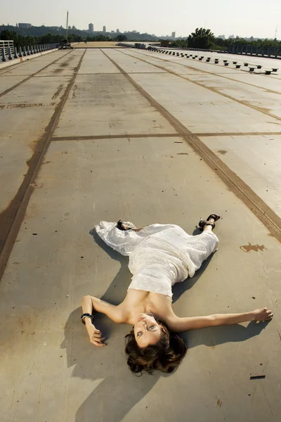 Bride lying on the road — Stock Photo, Image