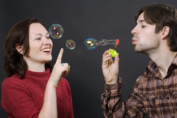 Couple blowing bubbles — Stock Photo, Image
