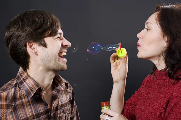 Happy couple blowing bubbles — Stock Photo, Image