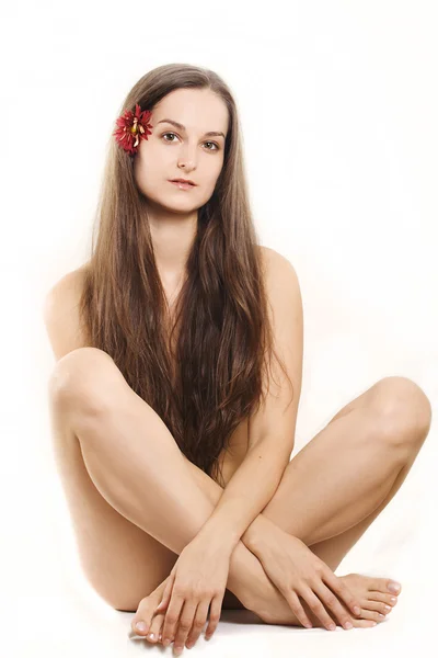 Mulher bonita com flor no cabelo — Fotografia de Stock