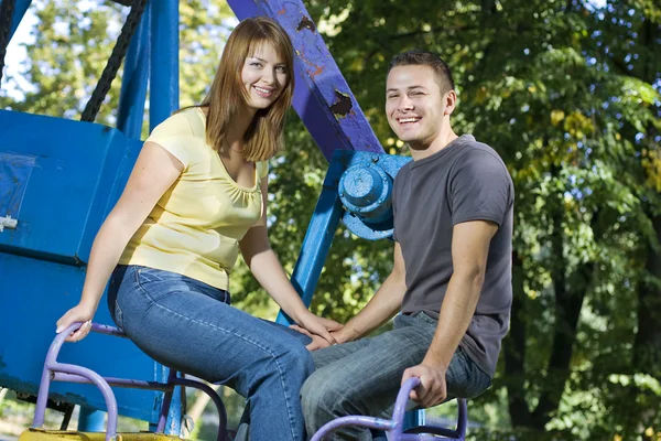 Cheerful couple on the carousel — Stock Photo, Image