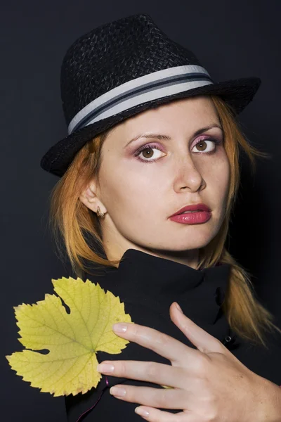 Genç bir kadın tutarak sarı yaprak — Stok fotoğraf