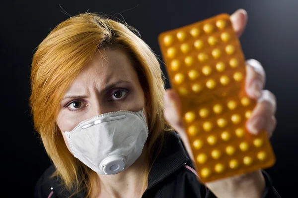 Frau mit Maske hält Pillen in Händen — Stockfoto