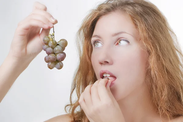 Beautiful girl eating grapes — Stock Photo, Image