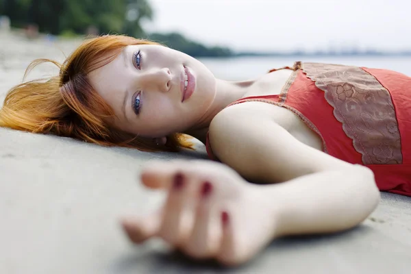 Beautiful woman laying on the sand — Stock Photo, Image