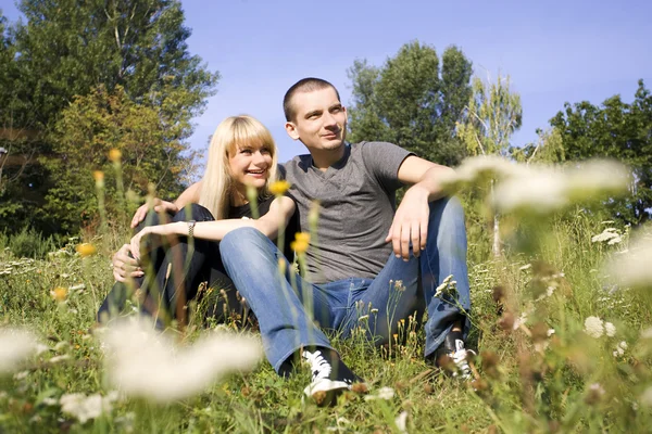 Para siedzi w wysokiej trawie — Zdjęcie stockowe