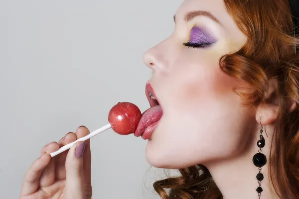 Woman licking candy — Stock Photo, Image