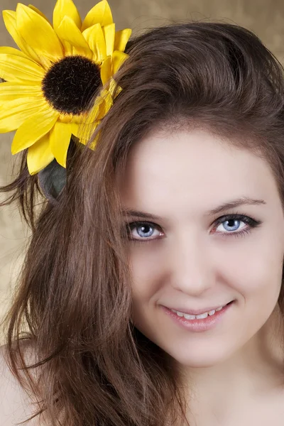 Beautiful young woman with a sunflower — Stock Photo, Image