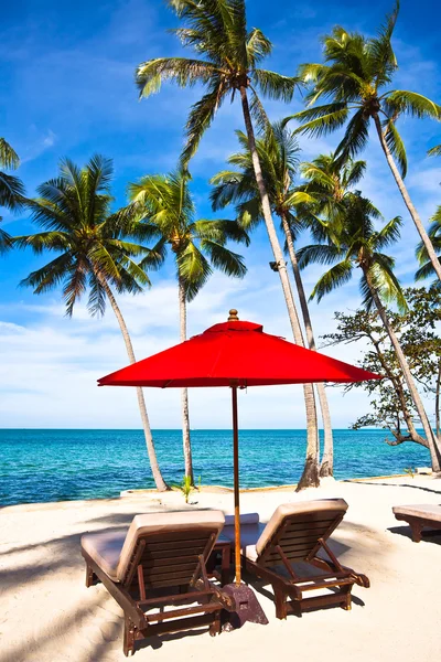 Kırmızı şemsiye ve kum plaj sandalye — Stok fotoğraf