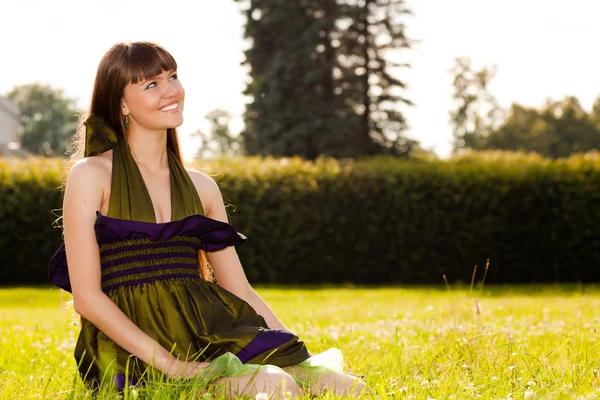 Bella ragazza sorridente è seduto sul gr — Foto Stock