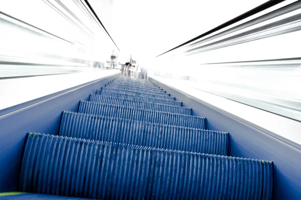 Подъем по движущемуся эскалатору на белый свет — стоковое фото