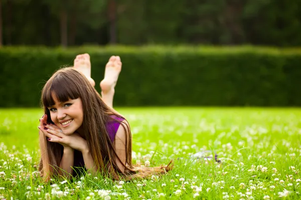 Досить усміхнена дівчина лежить на зеленому g — стокове фото