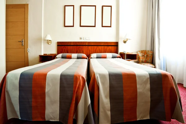 Quarto de hotel interior com camas e armações — Fotografia de Stock