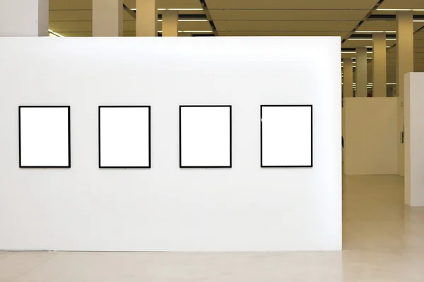 Exhibition with four empty frames on whi — Stock Photo, Image
