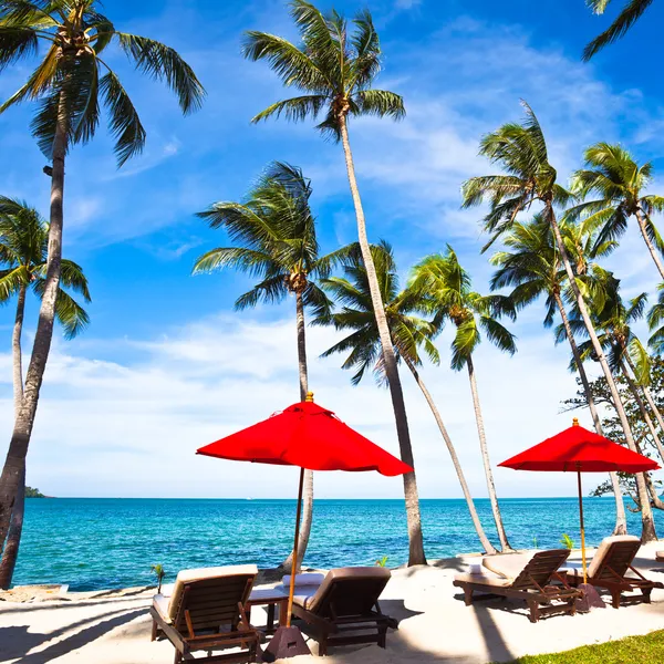 Kırmızı şemsiye ve sandalyelere kum plaj — Stok fotoğraf