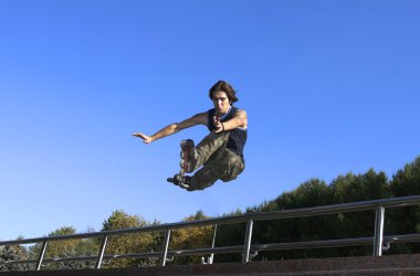 Roller boy jumping from parapet clipart