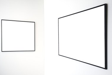 Two empty frames on white wall clipart