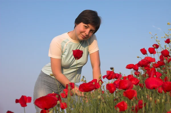 Симпатичная девушка на маковом поле — стоковое фото