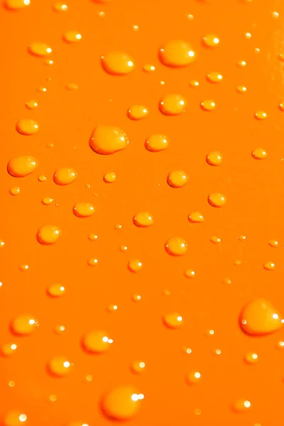 Gotas de agua sobre fondo metálico naranja —  Fotos de Stock