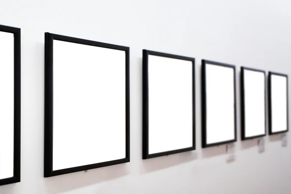 Empty frames on white wall — Stock Photo, Image