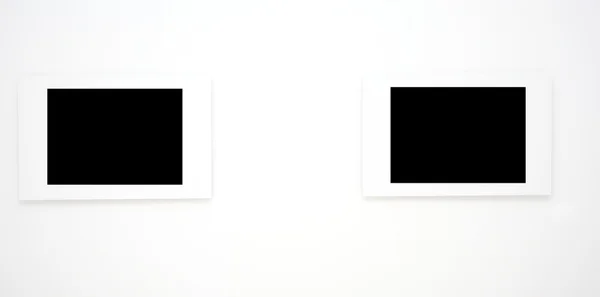Due cornici vuote su parete bianca — Foto Stock