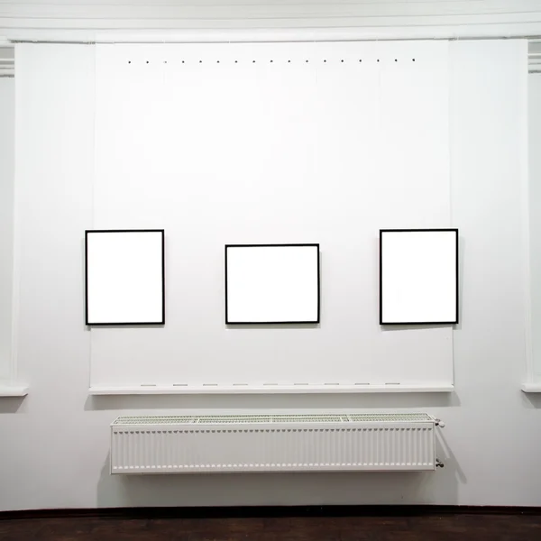 Three empty frames on white wall — Stock Photo, Image