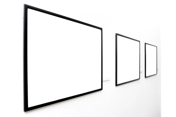Três molduras vazias na parede branca — Fotografia de Stock