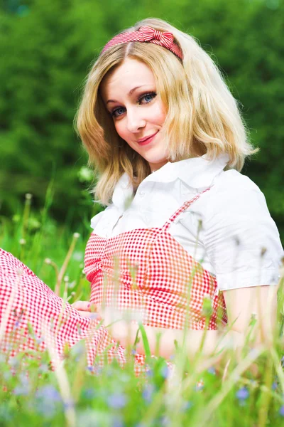 Bionda ragazza attraente sedersi su erba — Foto Stock