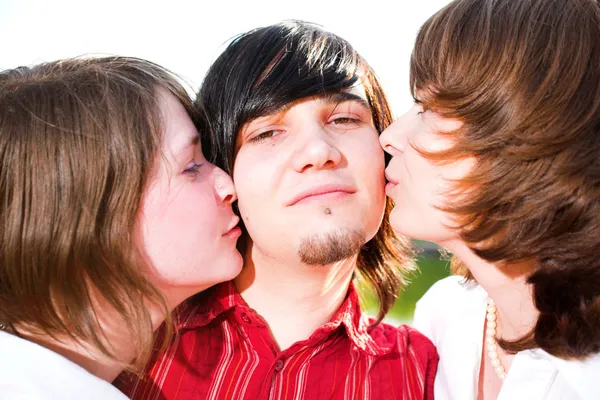 Girls kiss young guy — Stock Photo, Image