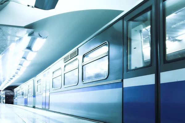 Blauwe snelle trein verblijven platform — Stockfoto